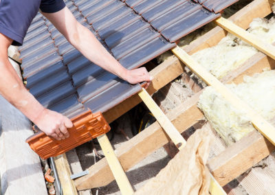 image showing a tradesman placing tiles on a roof